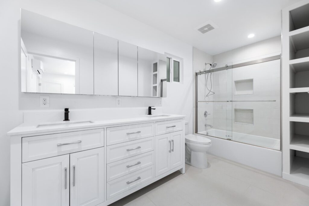 Modern white bathroom remodel with double vanity, glass shower, and shaker cabinets – Los Angeles ADU builder