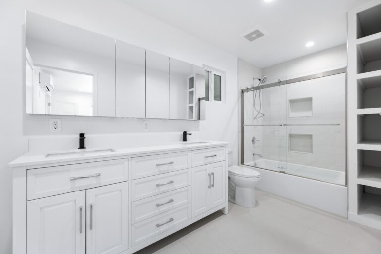 Modern bathroom inside Los Angeles ADU featuring white cabinetry, glass shower, and elegant fixtures built by M.E.Development,Inc–ADU Builders
